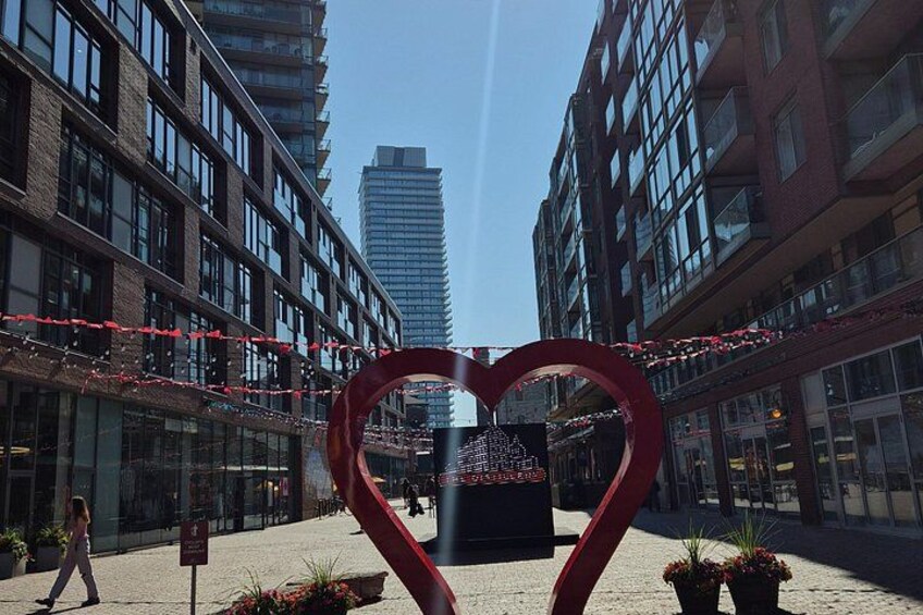 A heart-shaped sculpture in an urban plaza with buildings in the background. 4