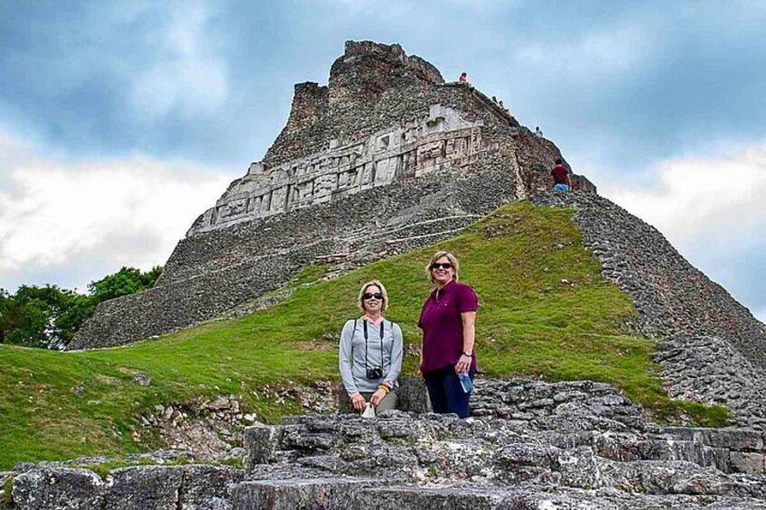 A large ancient pyramid-like structure with two people standing in front of it. 5