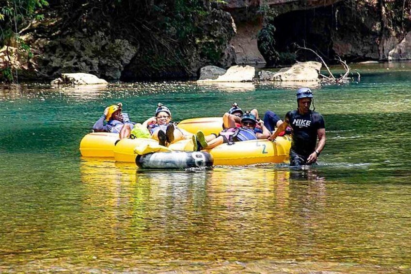 People in a yellow raft on a river surrounded by rocks and greenery. 3