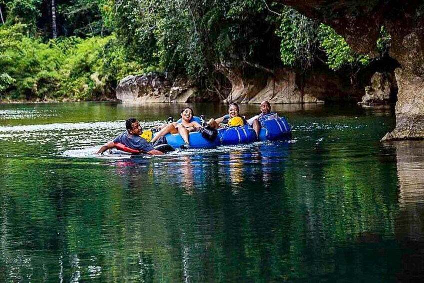 People floating on a raft in a river surrounded by greenery. 2