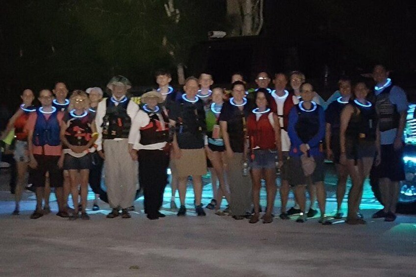 A group of people standing on a beach at night. 4
