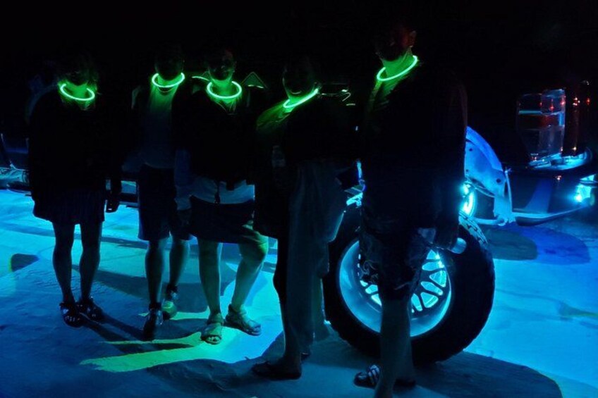 People with glowing green lights around their necks, a motorcycle, and a blue-lit environment. 5