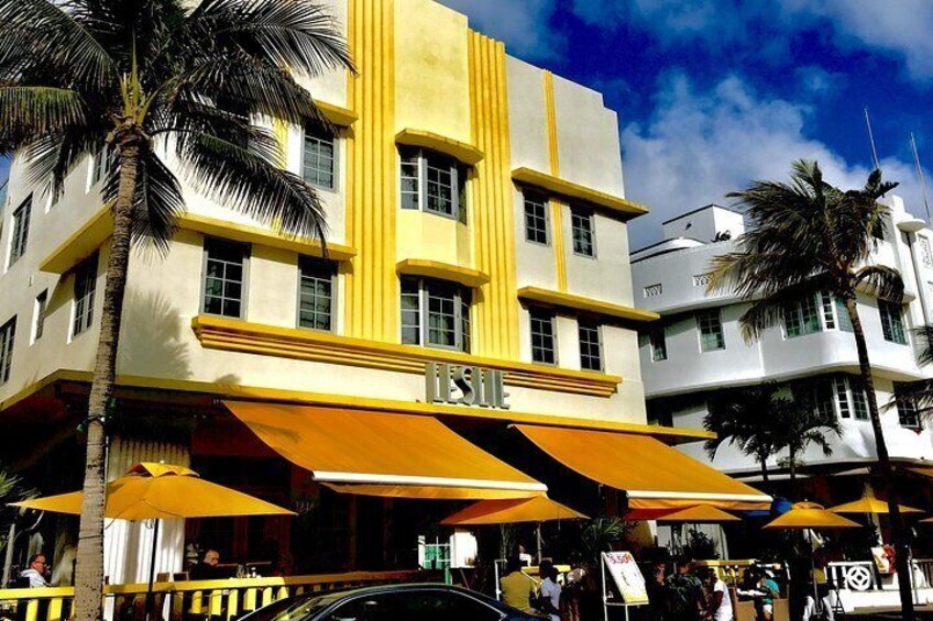 A building with yellow awnings and palm trees. 5