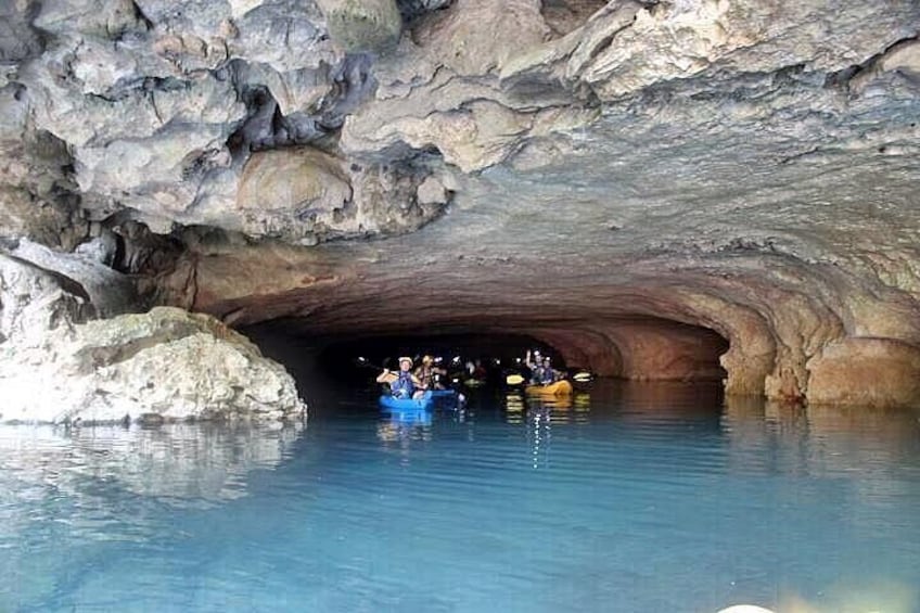 En grotta med en vattenyta inuti, där folk åker kajak. 1