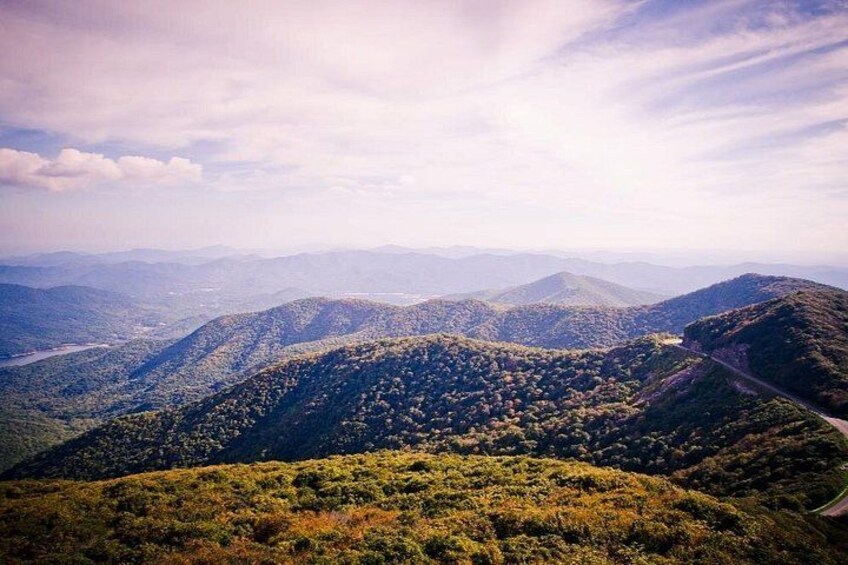 A mountainous landscape with dense forests and a winding road. 2