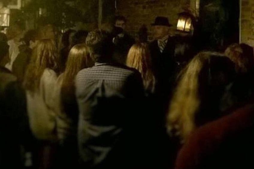 A group of people in a dimly lit indoor setting. 1