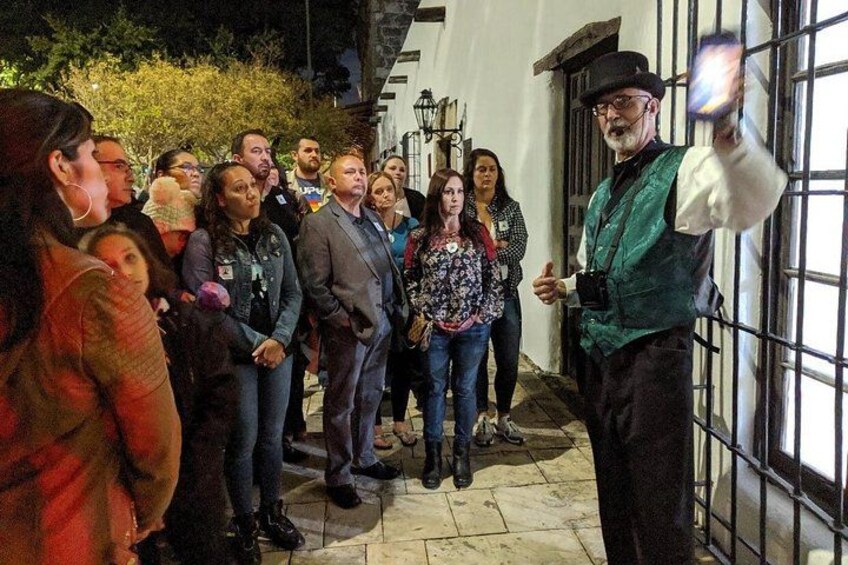 Un grupo de personas de pie frente a un edificio con ventanas con barrotes. 2