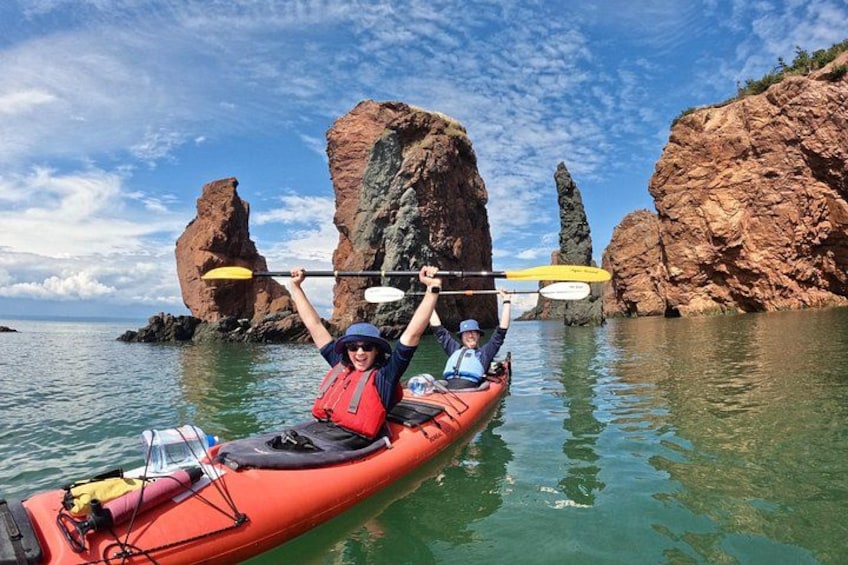 Una persona practica kayak en aguas tranquilas, con acantilados rocosos al fondo. 1
