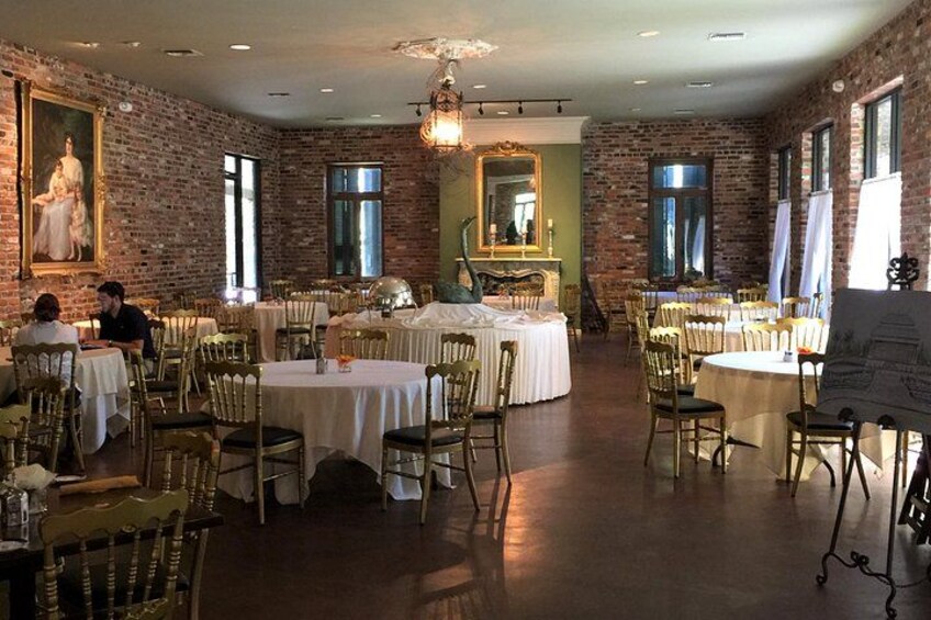 A restaurant with brick walls, round tables, and chairs. 2