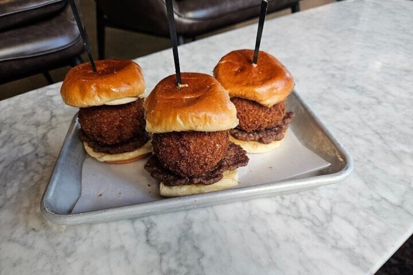 Three fried food sandwiches on a metal tray. 5