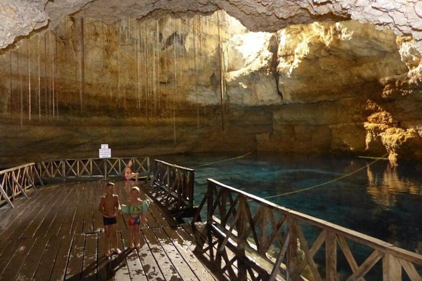 A wooden deck over a pool in a cave with stalactites. 1