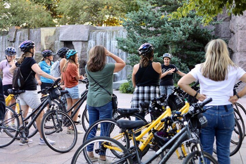 A group of people standing around bicycles in an outdoor setting. 3