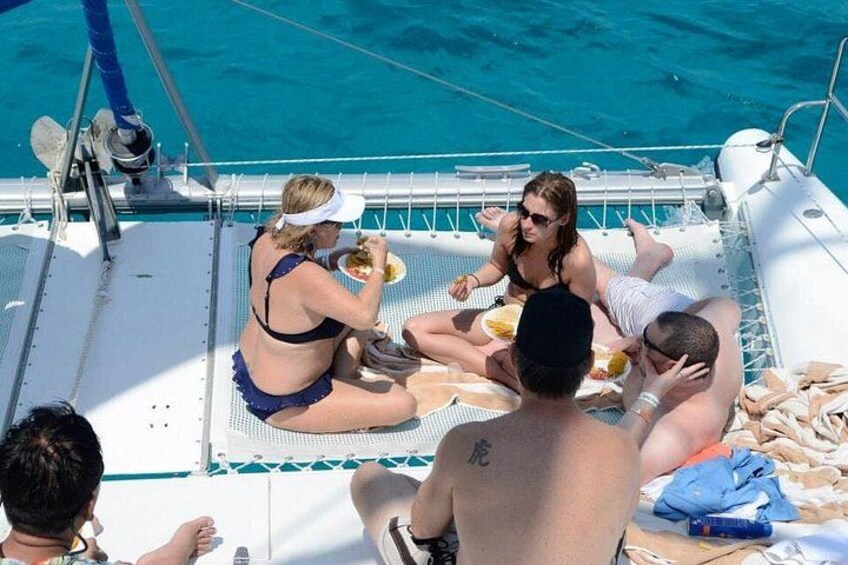 People on a boat with a pool, wearing swimwear, and eating. 3
