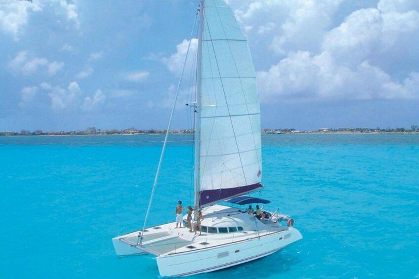 A sailboat on turquoise water with a clear sky. 4