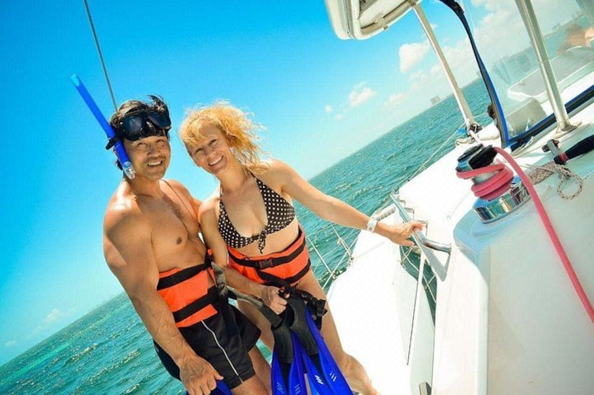 Two people on a boat with a clear blue sky and ocean in the background. 3