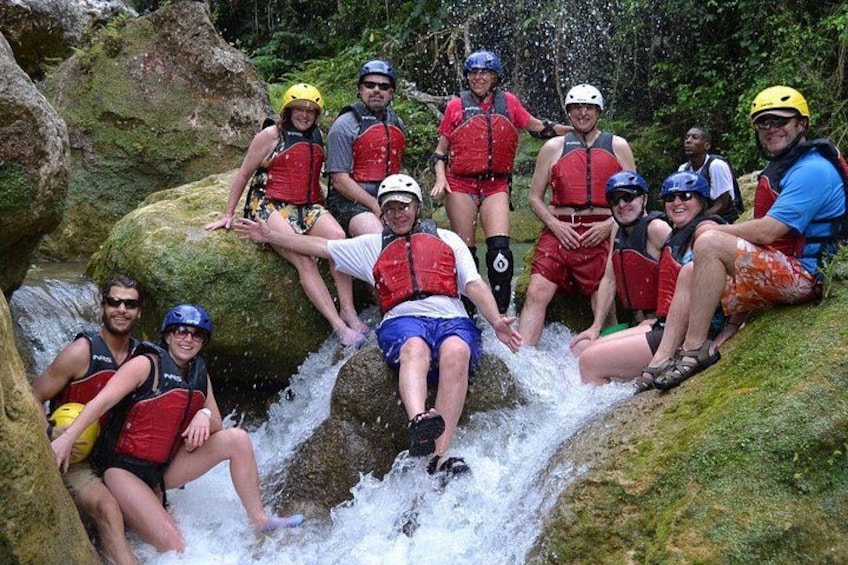 Un grupo de personas haciendo rafting en un río rodeado de rocas y vegetación. 2
