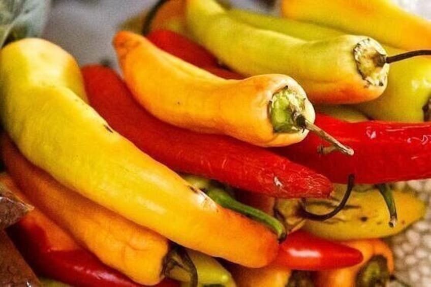 A pile of yellow and red chili peppers. 1