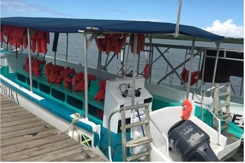 A boat with a covered seating area and life jackets. 1
