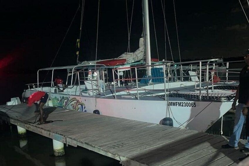A dock with a boat named 'MWFM230065' and a person standing on the dock. 5