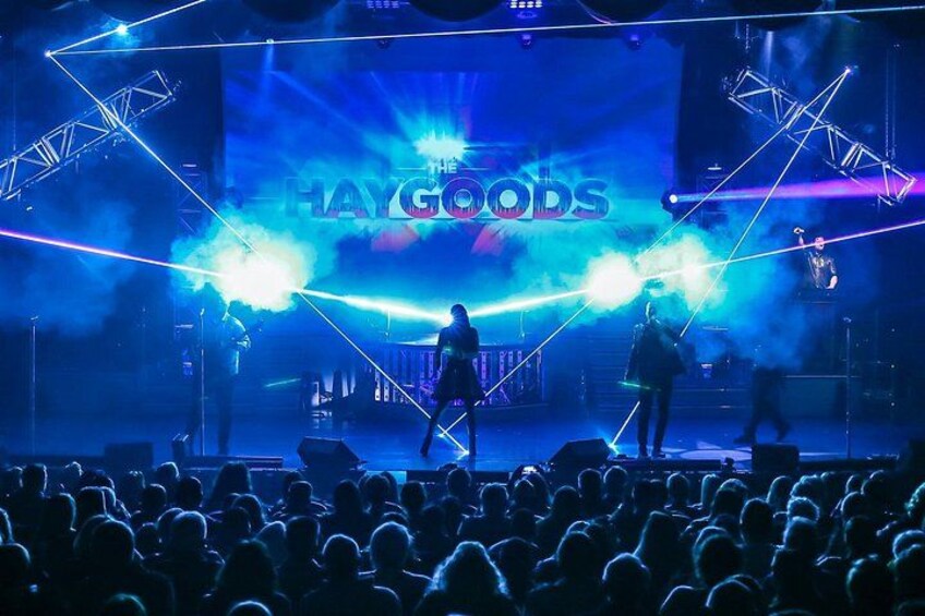 En konsertscen med en publik, scenbelysning och texten ”The Haygoods”. 2