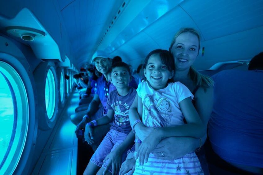 Una famiglia seduta nell'abitacolo di un aereo, con un effetto di illuminazione blu. 2