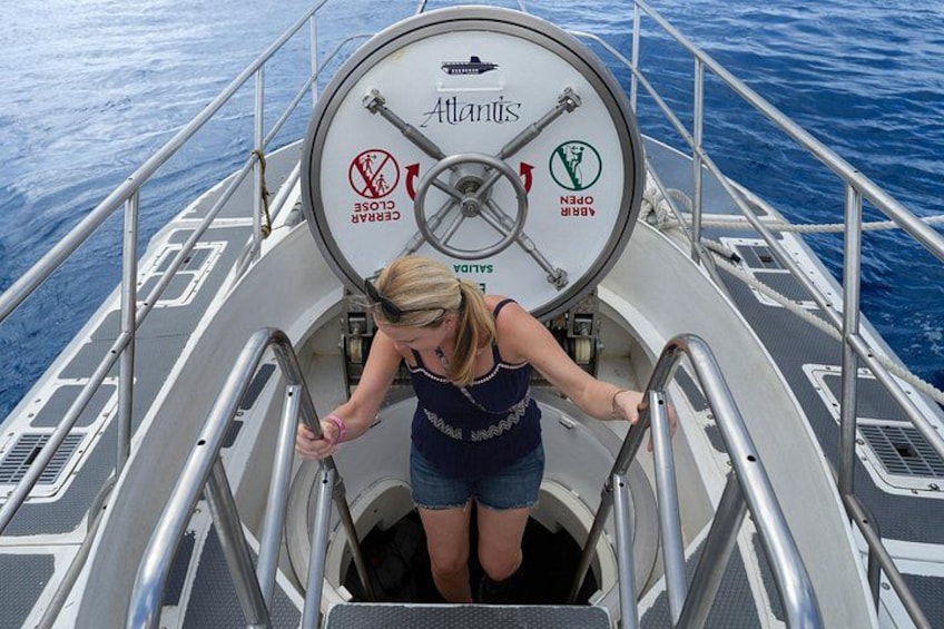 A person descending a metal staircase on a boat named Atlantis. 4