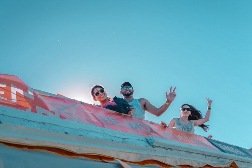 Three people standing on a roof with a red banner. 2