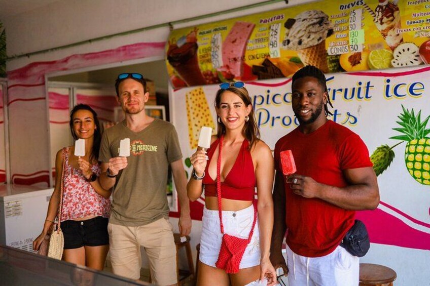 Persone che tengono gelati in mano davanti a una gelateria. 3