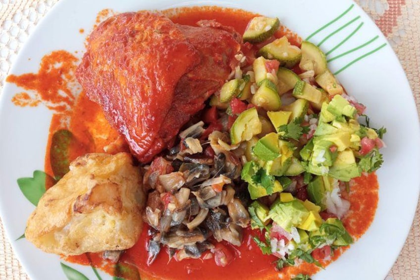 A plate of food with a fish, avocado, and a red sauce. 3
