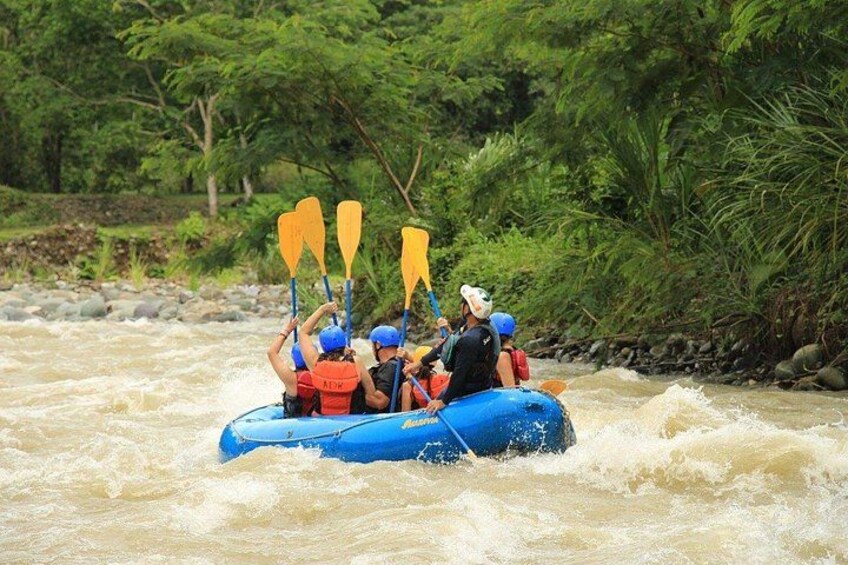 A group of people rafting on a river surrounded by greenery. 3