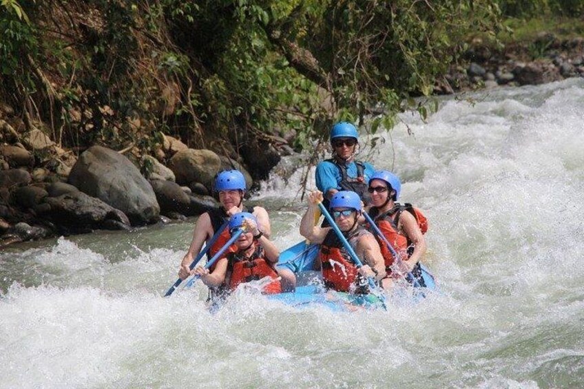 A group of people rafting on a river surrounded by rocks and greenery. 2