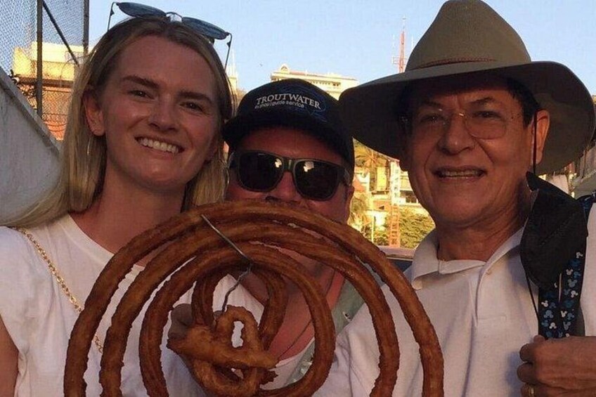 Three people holding a large, coiled rope. 3