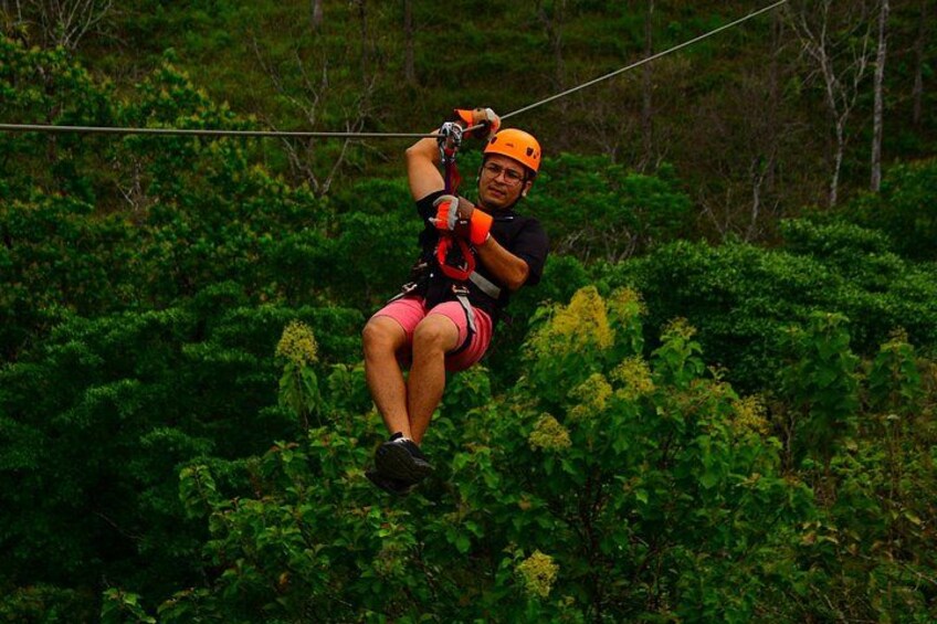 A person zip-lining through a forested area. 4