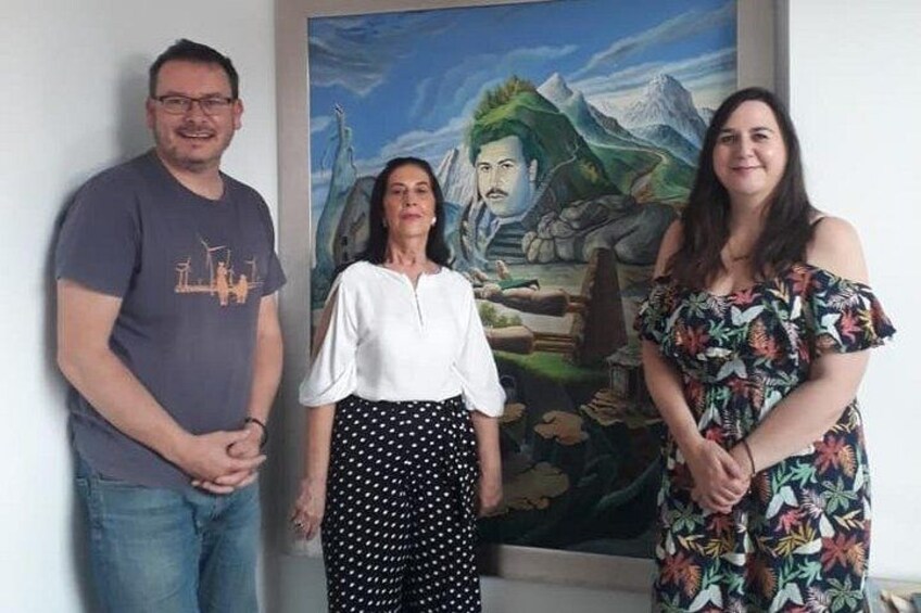 Three people standing in front of a painting. 5