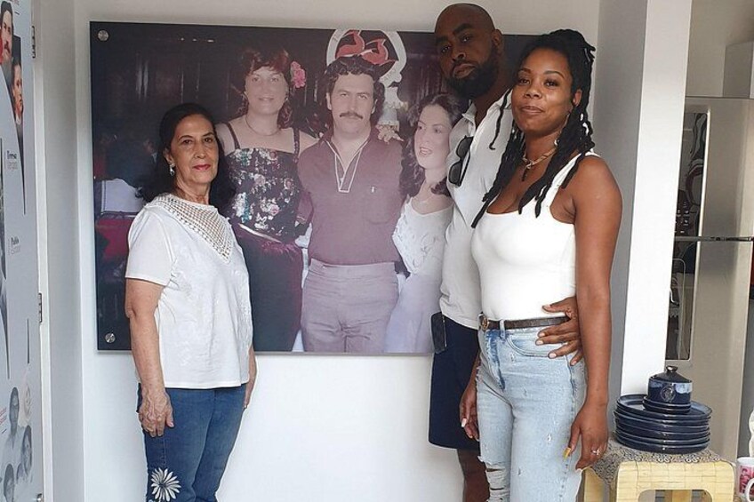 A group of people standing in front of a framed photograph. 4