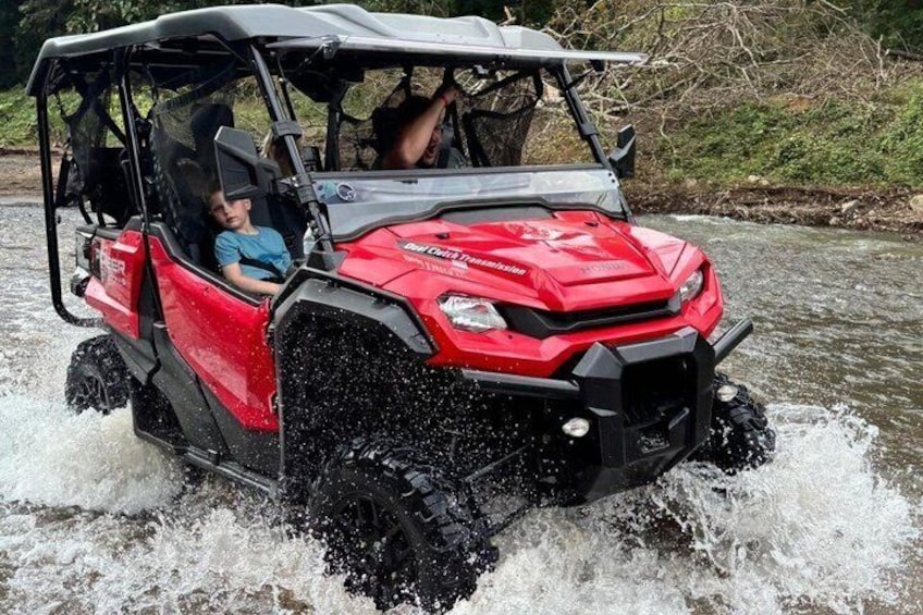 Un quad rouge traverse une rivière. 1