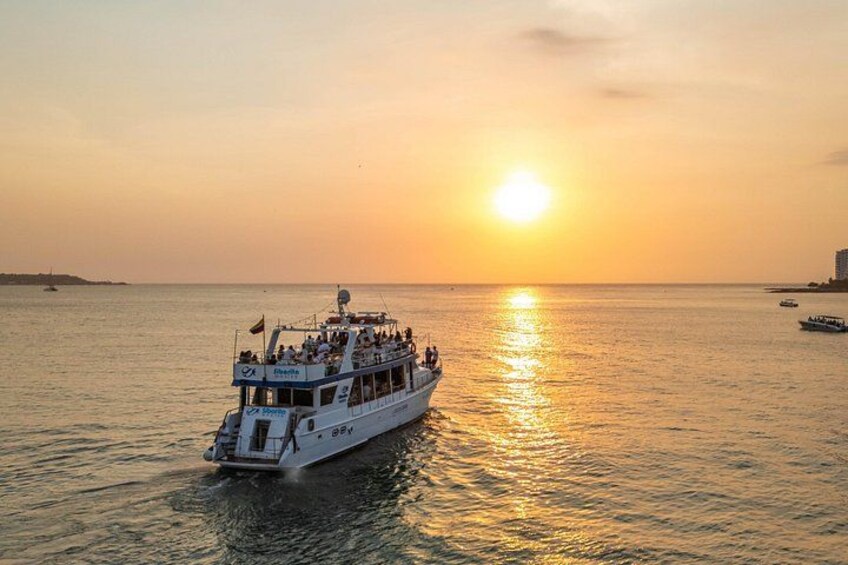 A boat with passengers on a body of water during sunset. 5