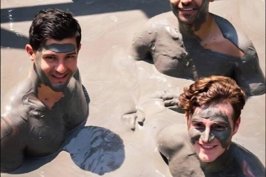 Tres personas cubiertas de barro, probablemente disfrutando de un baño de lodo o jugando con el barro. 1
