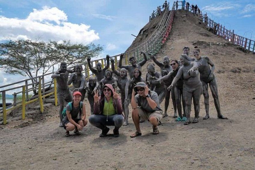 Un groupe de personnes posant devant une grande statue représentant une personne, sur une colline. 2