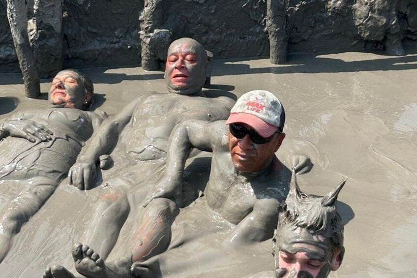 Des personnes couvertes de boue sur une plage. 1