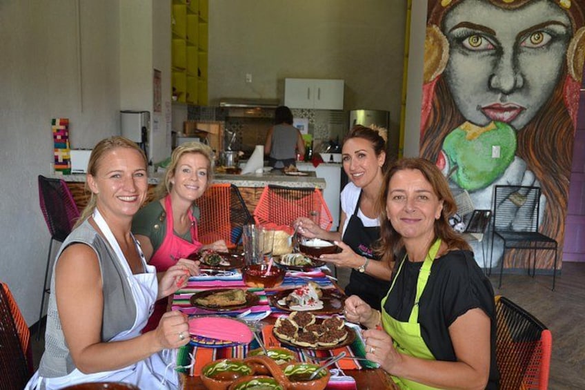 A group of people sitting around a table with various food items and drinks. 2