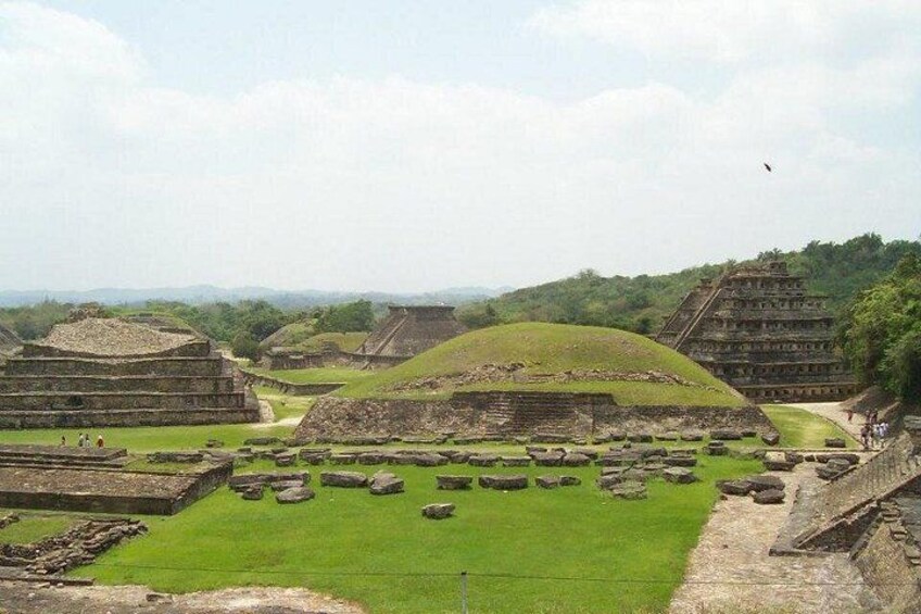 Ancient ruins with stepped pyramids and a large open plaza. 2