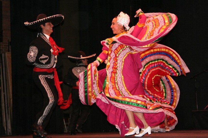 A performer in a colorful dress spinning on stage. 3