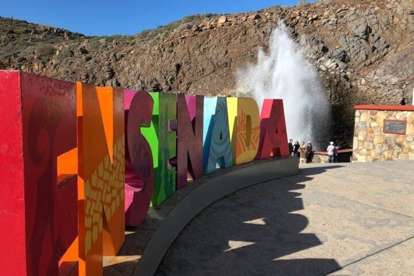 Colorful letters spelling 'ENINADA' with a water fountain in the background. 1