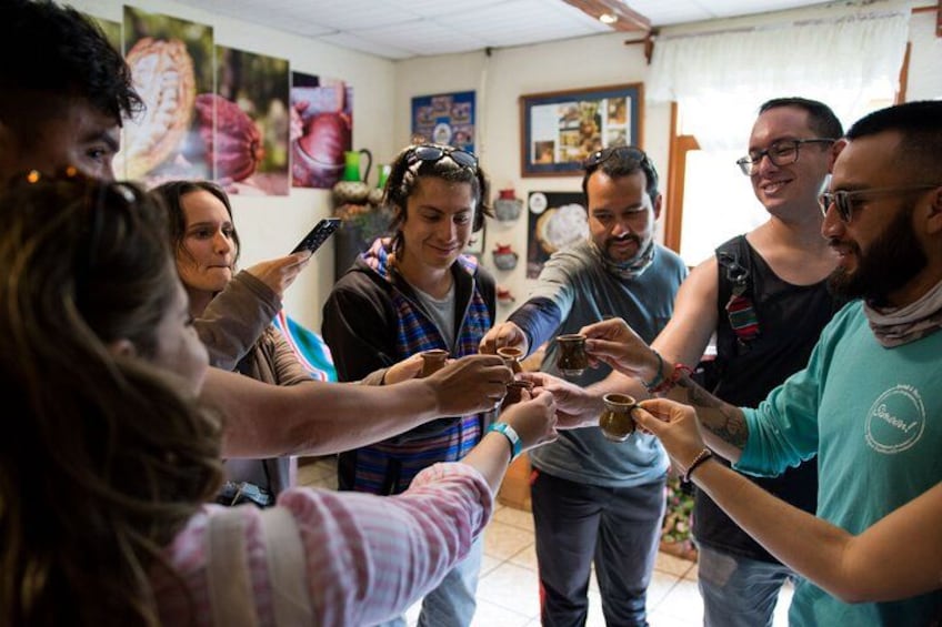 Un grupo de personas brindando con pequeñas copas en un ambiente interior informal. 3