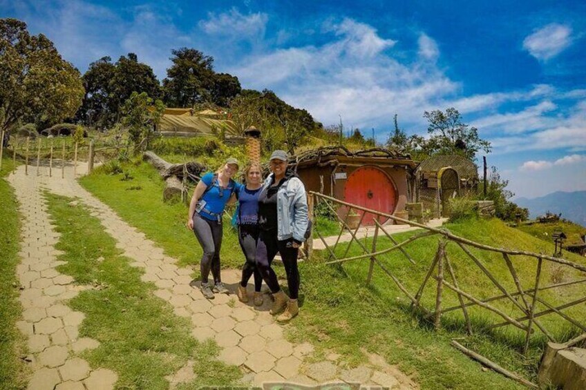 Un groupe de personnes se trouve sur un chemin de pierre, avec un bâtiment rouge en arrière-plan. 1