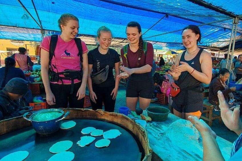 People at a market stall with food items. 4