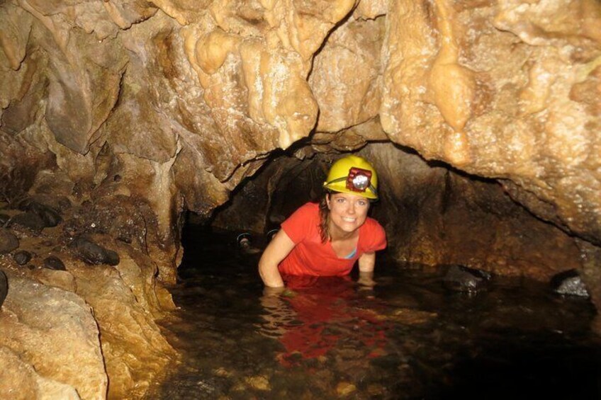 A person in a cave with water, wearing a helmet. 5