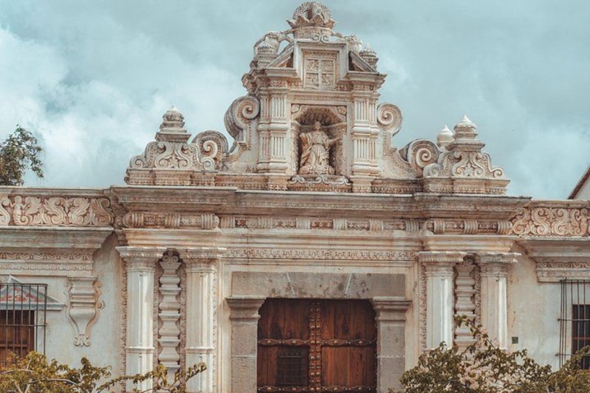 A historic building with ornate carvings and a large wooden door. 2