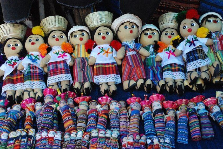 A collection of traditional dolls and colorful woven textiles. 2
